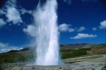 Der eruptierende Strokkur Geysir. Das Wasser steigt zum leicht bewlkten Himmel hinauf