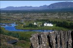 Weite Aussicht auf den Thingvellir Nationalpark mit einen Fluss der vor weien Husern fliet